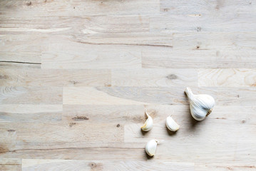 clove of white garlic on an oak tree cutting board seen from above