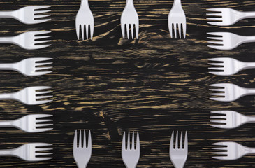 plastic forks on wooden background