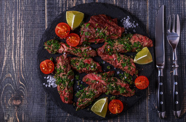 Steak served on a board with salsa verde.