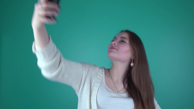 Селфи.  Девушка фотографирует сама себя на телефон