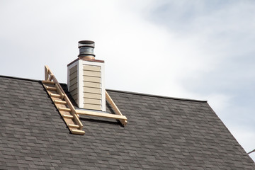 Chimney being painted surrounded by a construction frame for worker access