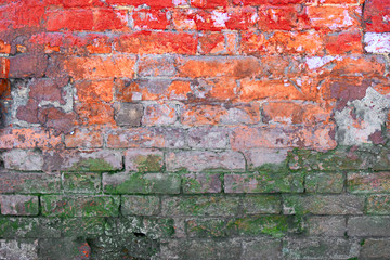 Half weathered brick wall painted in red and orange