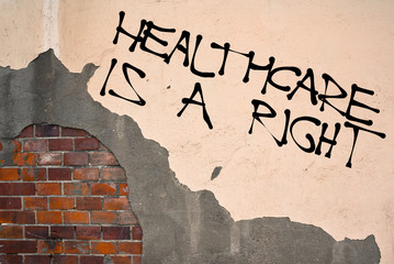 Handwritten graffiti Healthcare Is a Right sprayed on the wall, anarchist aesthetics 