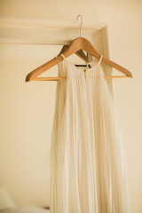 Fototapeta na wymiar white wedding dress on a hanger hanging on mirror