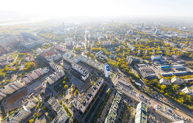 Aerial city view with crossroads, roads, houses, buildings and parks .