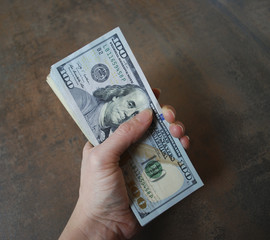 Woman hand hold cash dollar banknotes. Only hundreds.