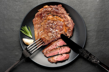 Medium rare grilled Steak Ribeye on black background. Top view