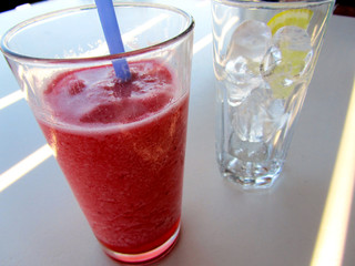 Granita alla fragola e bicchiere pieno di ghiaccio con limone