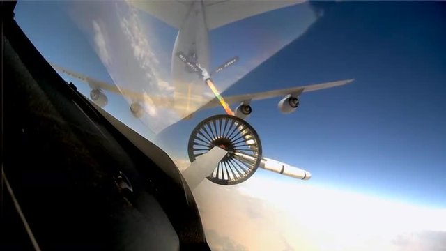 POV shots from the cockpit of a fighter plane as it is refueled in midair.