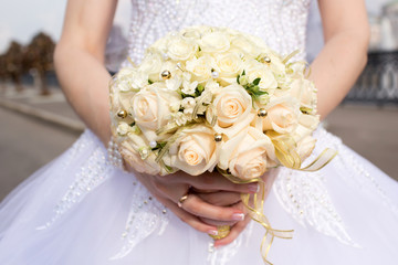 Beautiful wedding bouquet in hands of the bride