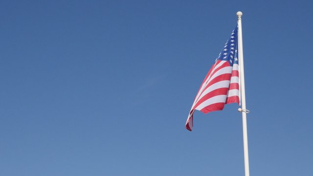 United states of America famous flag in front of blue sky waving 4K 2160p 30fps UltraHD footage - Recognizable American flag floating against clear blue sky 4K 3840X2160 UHD video 