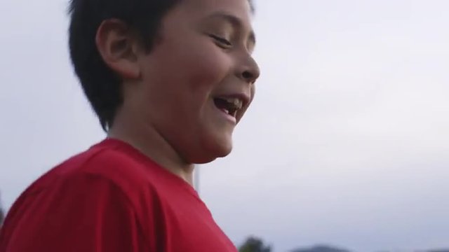Boy smiles and then throws frisbee