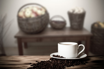 Coffee in a cup on wooden table opposite a defocused the interio