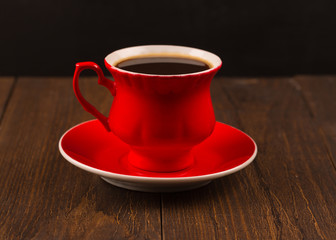 Steaming coffee cup on black wood background