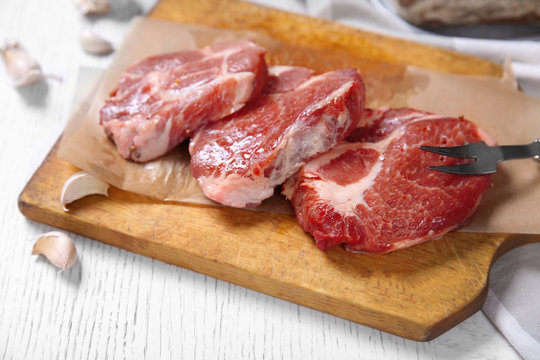 Marbled beef steak and spices on wooden background