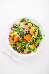 Fresh salad with fruits and greens on white background top view. Healthy food.