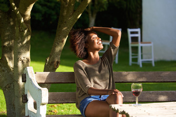 Naklejka premium Smiling african woman relaxing outside in garden