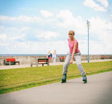 Active young woman rollerskating outdoor.