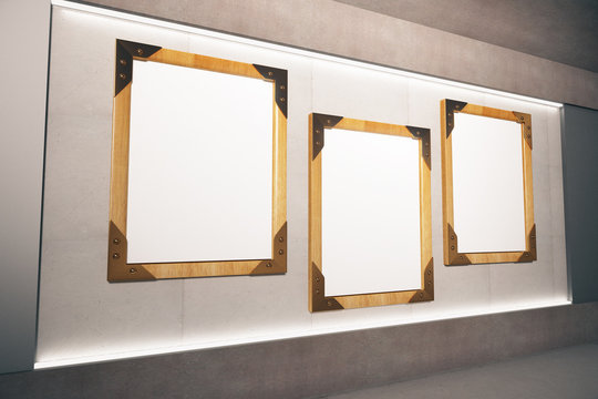 Blank wooden picture frames on beige wall in empty room, mock up