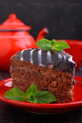 chocolate cake on a red plate on a black background