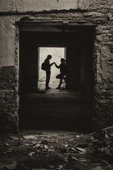 Silhouettes of boy and girl meeting secretly in abandoned space