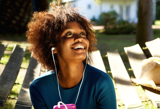 Smiling woman listening to music with cellphone and earphones