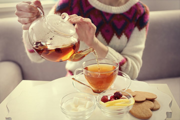 Woman pouring tea into the cup