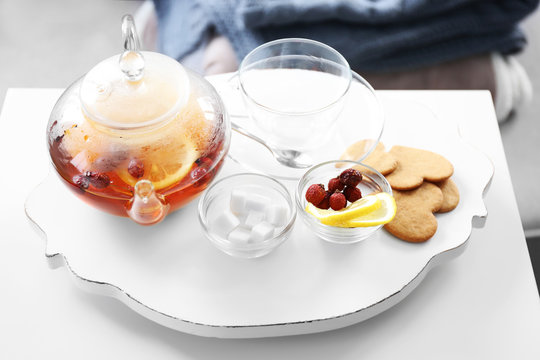 Tea set with lemon and biscuits on a white wooden mat