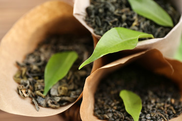 Dry tea with green leaves in cornets, closeup