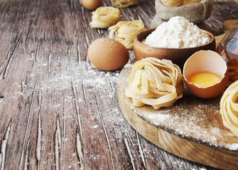 Fototapeta na wymiar Uncooked pasta with flour on the table, selective focus