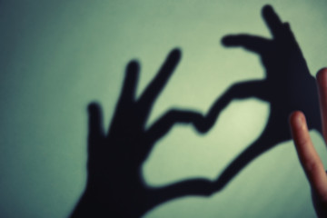 Hand shaped heart on green background