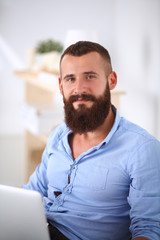 Obraz premium Young businessman sitting on chair in office