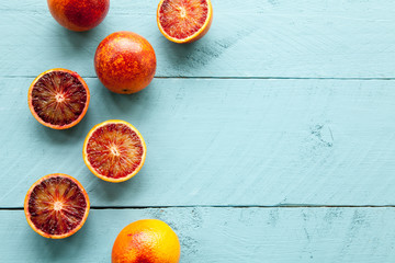 Several blood oranges on blue wooden background