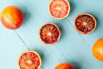 Several blood oranges on blue wooden background