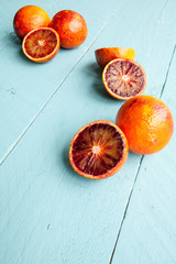 Several blood oranges on blue wooden background