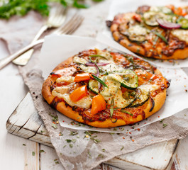 Vegetarian pizza with addition of pepper, zucchini, onion and herbs