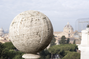 close-up of a ball of travertine marble with the background the view of Rome