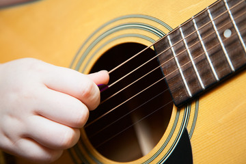 Little boy is playing the guitar