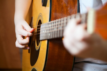 Fototapeta premium Little boy is playing the guitar