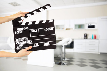 Operator holding clapperboard during the production of film indoors