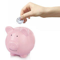 Piggy bank and a hand holding timer above it on white background
