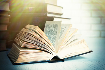Open book on table on brick wall background