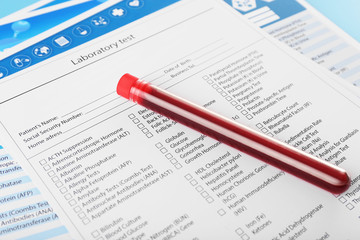 Blood in test tubes and investigation form on the table, close-up