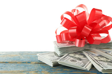 Pile of dollars with bow as gift isolated on white