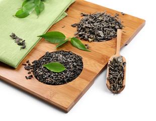 Dry tea with green leaves in wooden utensil, isolated on white