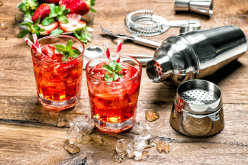 Red drink with ice. Cocktail making bar tools
