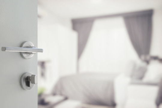 opened white door to modern bedroom interior