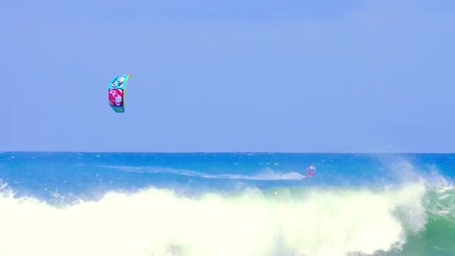 Kite Surfing on blue sea water at sunny day distant view. Water sport background