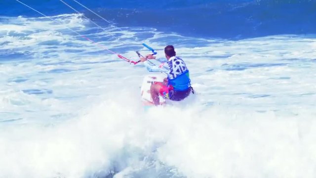 Amazing skills of strapless kite surfing rider on big rough waves in open sea