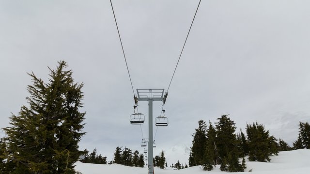 Ultra high definition 4k time lapse movie of moving ski chair lifts and skiers on the slopes of snow covered Mount Hood in Government Camp Oregon 4096x2304